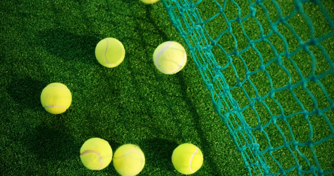 Close-Up of Tennis Balls Scattered on Green Turf with Netting - Free Images, Stock Photos and Pictures on Pikwizard.com