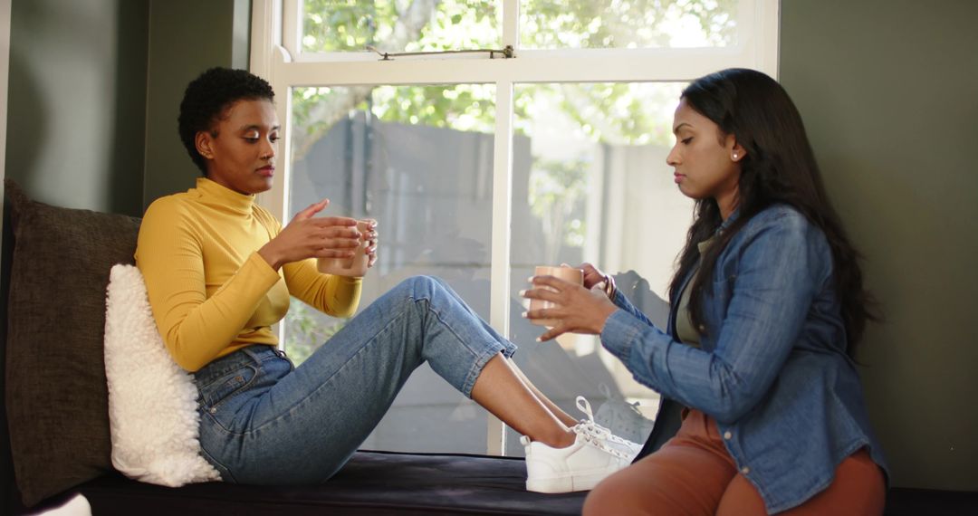 Diverse Friends Chatting in Cozy Home Setting by Window