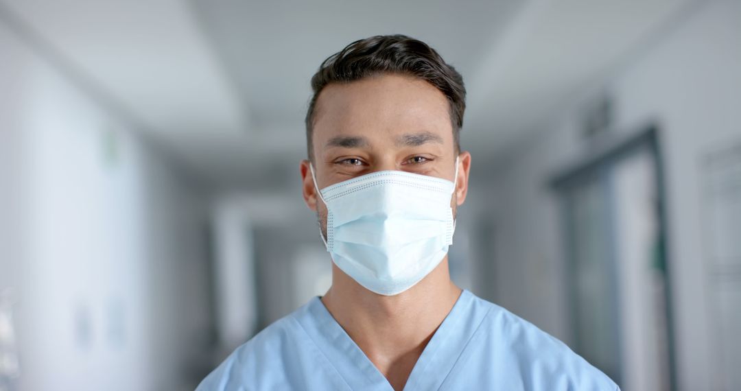 Young Healthcare Worker Wearing Surgical Mask in Hospital Corridor - Free Images, Stock Photos and Pictures on Pikwizard.com