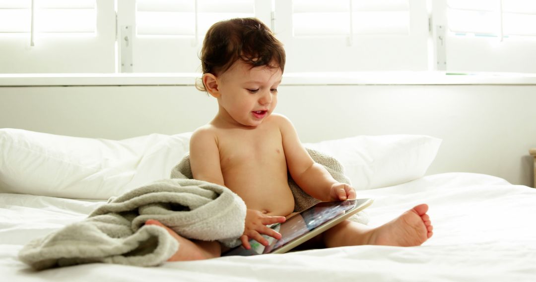 Curious Toddler Playing with Tablet on Bed - Free Images, Stock Photos and Pictures on Pikwizard.com