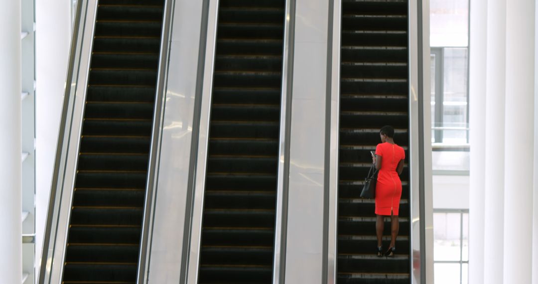 Businesswoman in Red Dress on Office Escalator - Free Images, Stock Photos and Pictures on Pikwizard.com