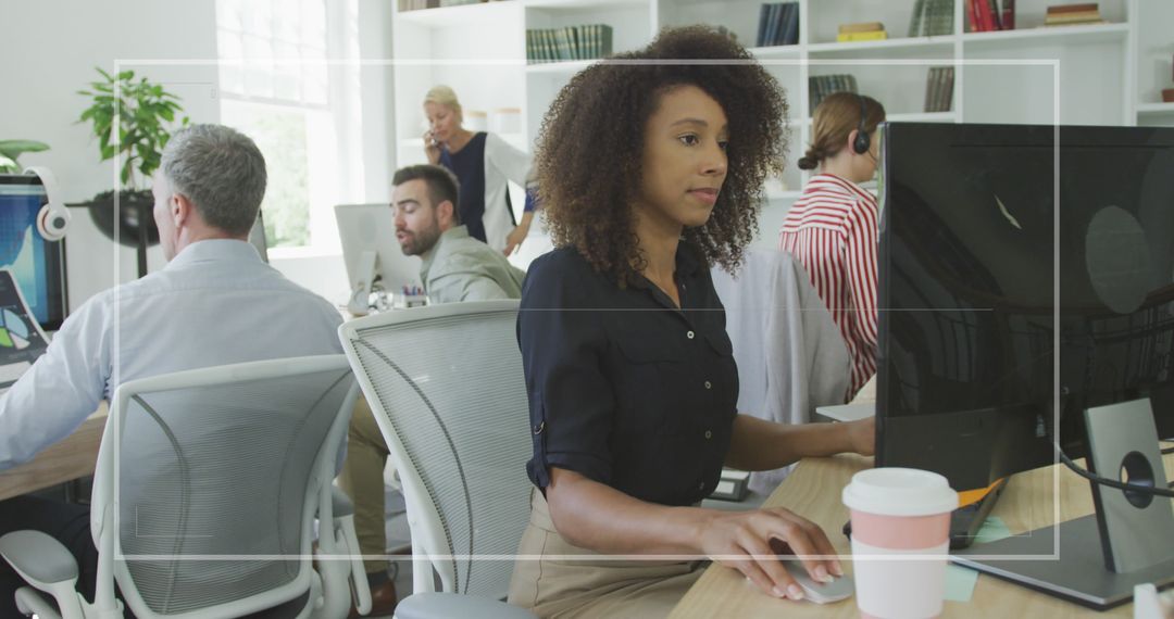 Busy Office with Diverse Team Working Together on Computers