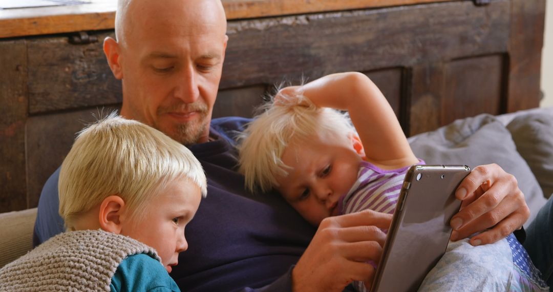 Father Engaging with Children on Digital Tablet at Home