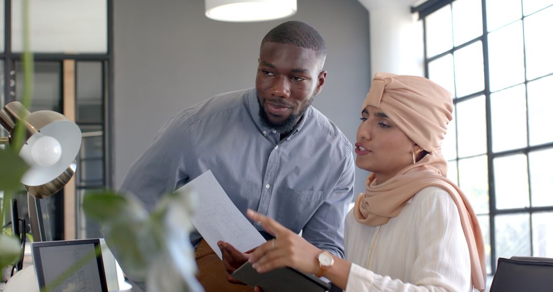 Diverse Team Discussing Office Project with Documents and Technology