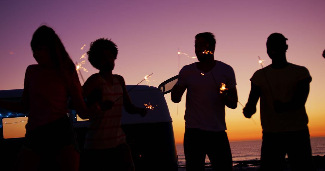 Group of Friends Celebrating with Sparklers by the Beach at Sunset - Free Images, Stock Photos and Pictures on Pikwizard.com