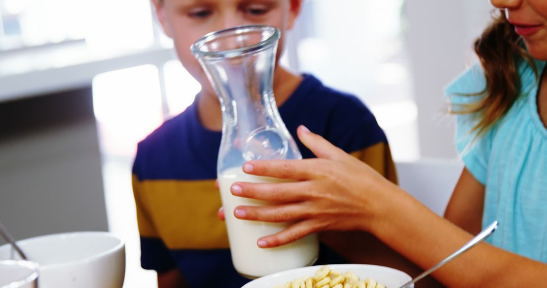 Children Having Breakfast, Pouring Fresh Milk into Cereal - Free Images, Stock Photos and Pictures on Pikwizard.com