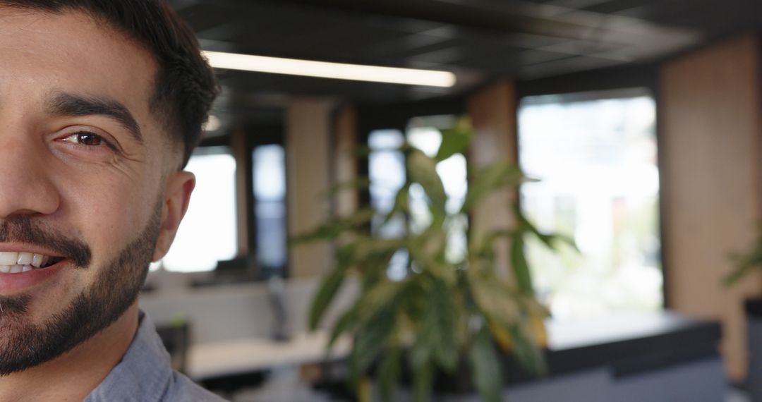 Smiling Man Typing at Office Desk with Modern Interior