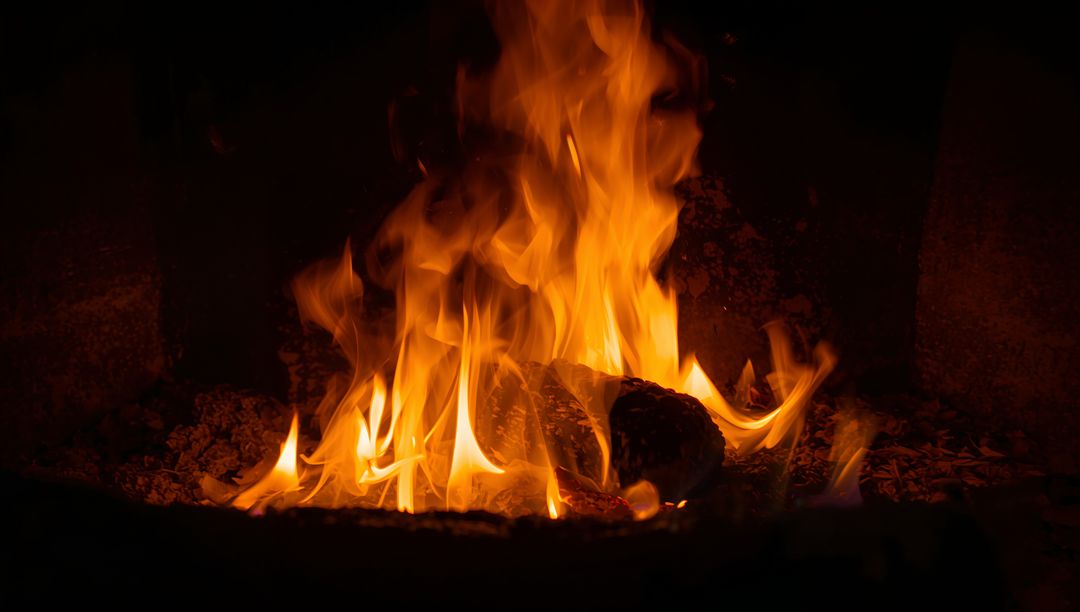 Crackling Flames Warming Charred Log with Glowing Embers in Hearth