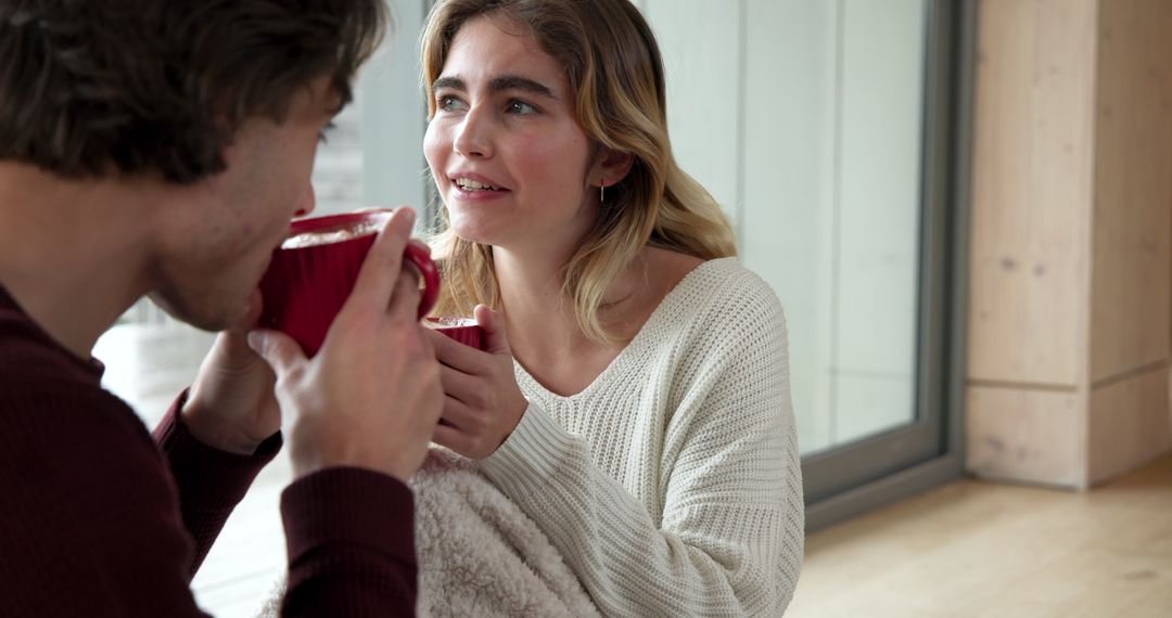 Couple Relaxing with Hot Drinks in Cozy Home Setting