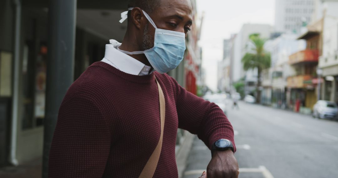 Man Wearing Mask Using Smartwatch in Urban Street - Free Images, Stock Photos and Pictures on Pikwizard.com