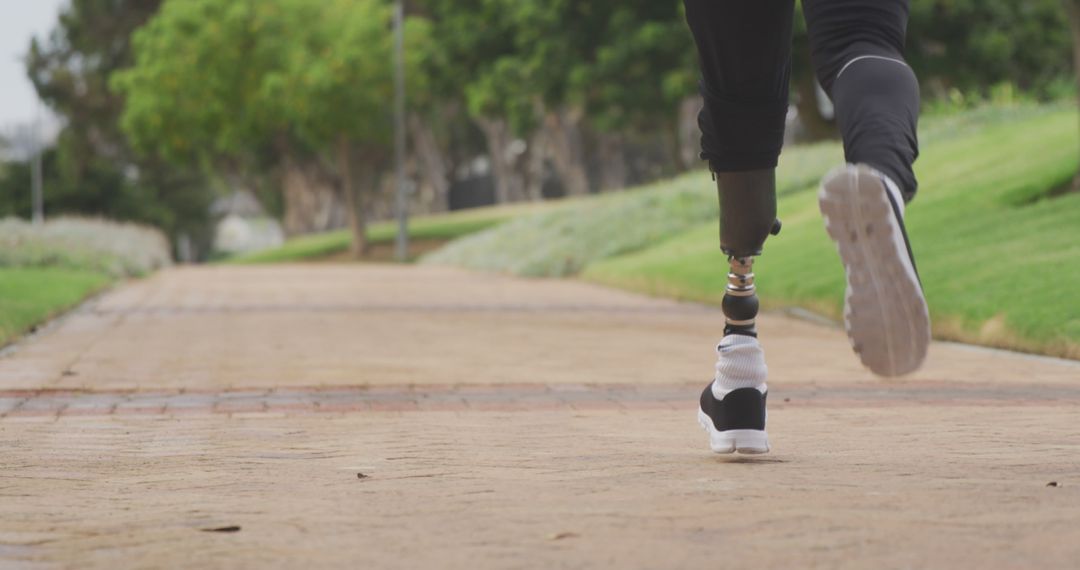 Athlete Running on Park Path With Prosthetic Leg - Free Images, Stock Photos and Pictures on Pikwizard.com