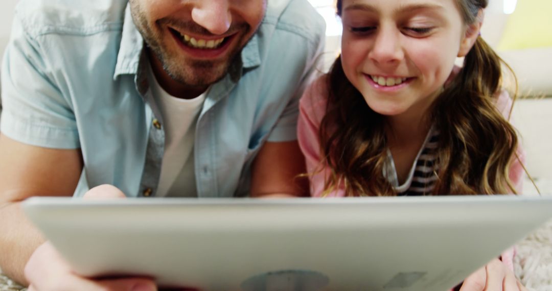 Father and Daughter Smiling While Using Digital Tablet Together - Free Images, Stock Photos and Pictures on Pikwizard.com