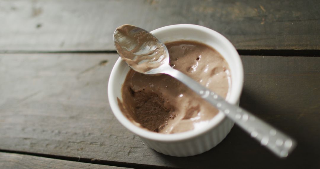 Image of chocolate pudding with spoon on a wooden surface - Free Images, Stock Photos and Pictures on Pikwizard.com