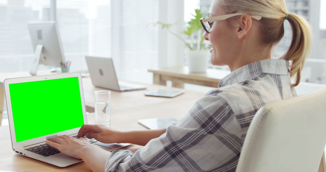 Businesswoman Using Laptop with Green Screen in Modern Office - Free Images, Stock Photos and Pictures on Pikwizard.com