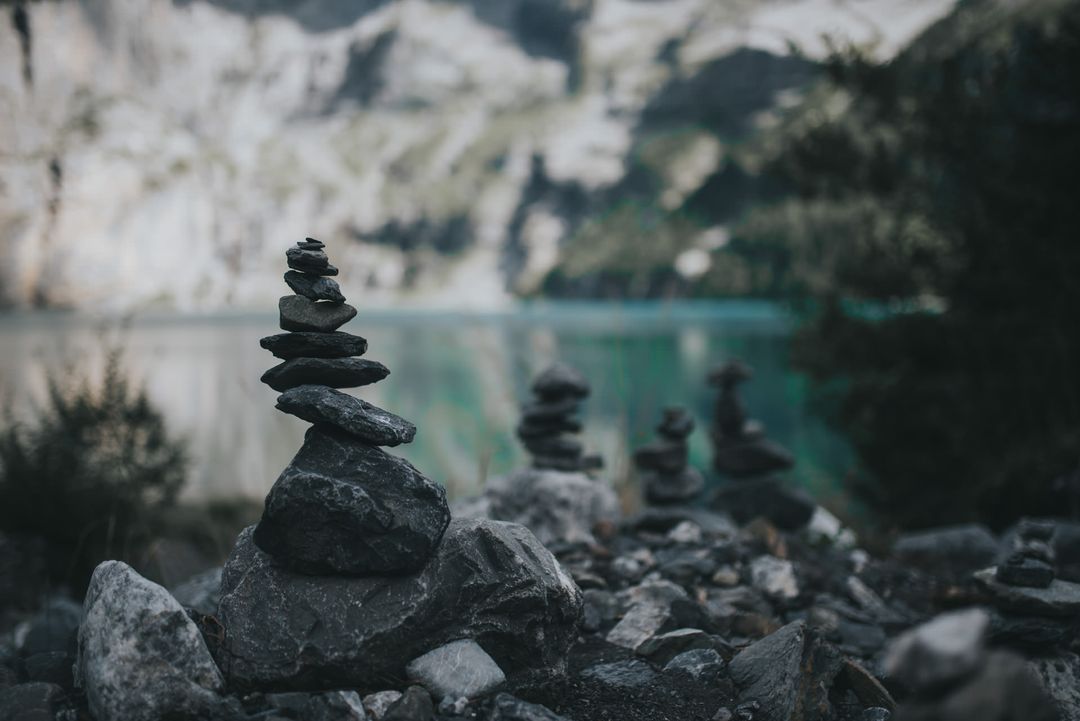 Serene Pile of Stones by Lake with Mountainous Landscape