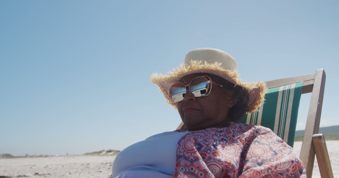 Senior Woman Relaxing on Beach Chair Under Sunny Sky - Free Images, Stock Photos and Pictures on Pikwizard.com