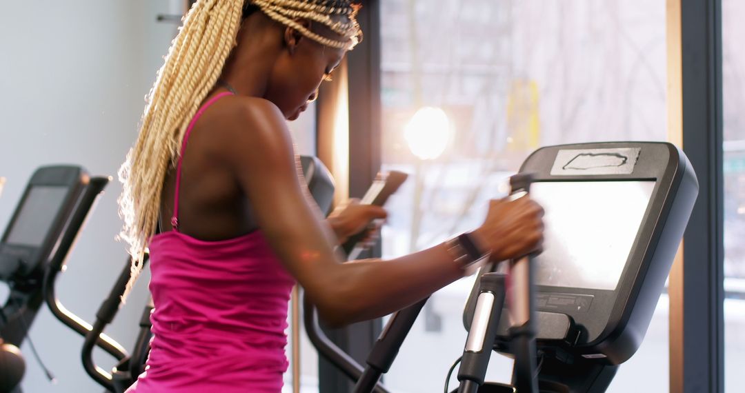 Focused Young Woman Exercising on Elliptical for Fitness - Free Images, Stock Photos and Pictures on Pikwizard.com