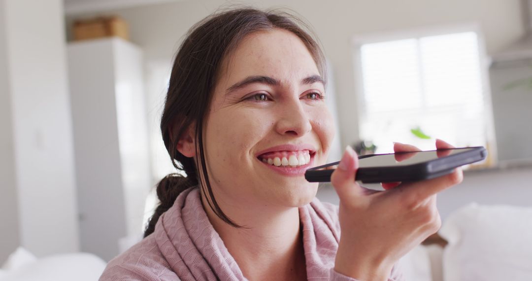 Smiling Woman Using Voice Command on Smartphone at Home - Free Images, Stock Photos and Pictures on Pikwizard.com