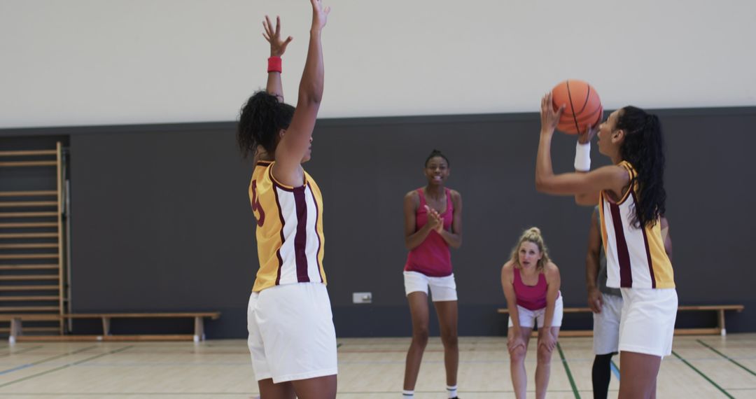 Diverse Group of Women Playing Intense Basketball Game in Gym