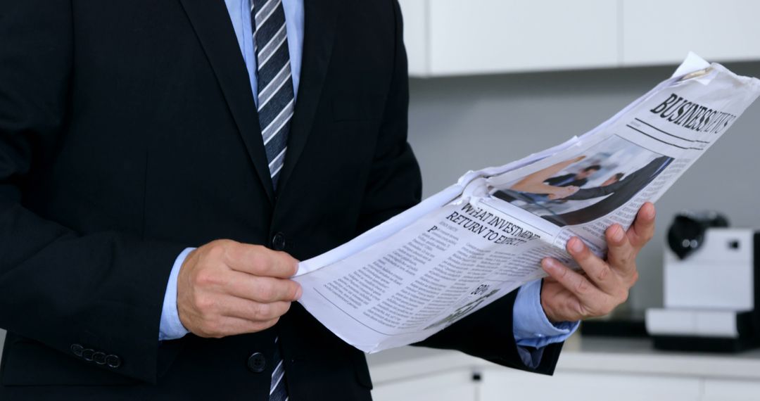 Businessman Reading Newspaper in Office - Free Images, Stock Photos and Pictures on Pikwizard.com