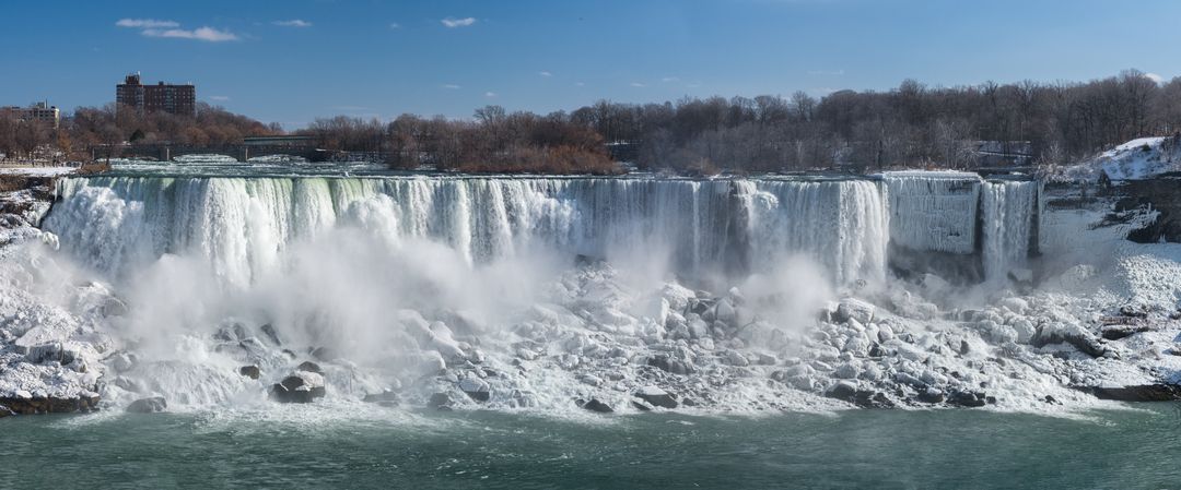 Panoramic Niagara Falls winter cascade with icy rocks, rushing mist and frozen edges