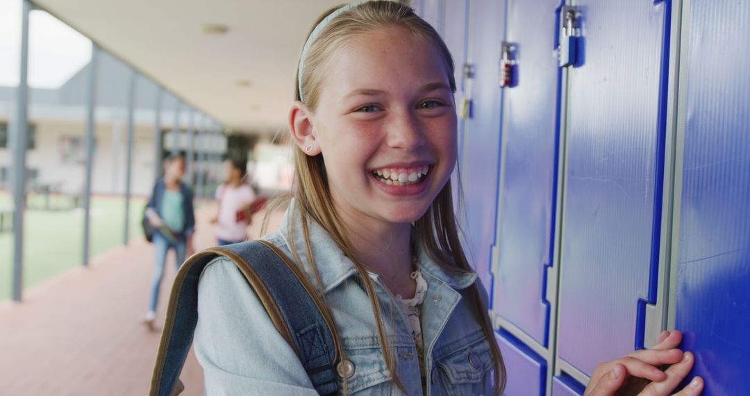 Smiling Schoolgirl Outdoors Near Blue Lockers - Free Images, Stock Photos and Pictures on Pikwizard.com