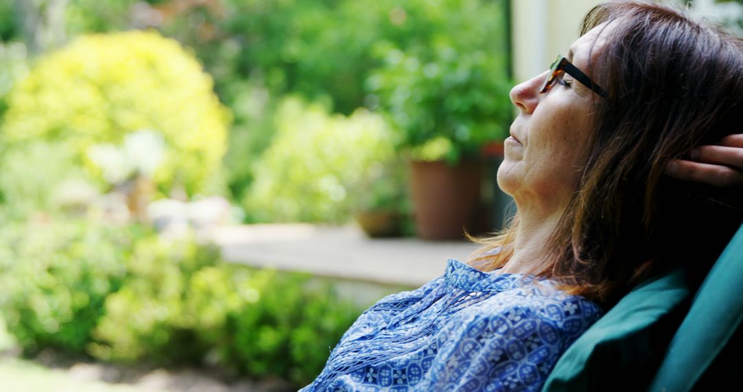 Mature Woman Relaxes Outdoors in Peaceful Garden Setting - Free Images, Stock Photos and Pictures on Pikwizard.com