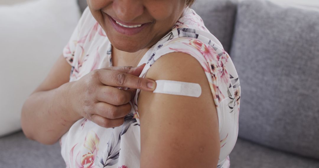 Smiling Woman Showing Bandage After Vaccination at Home - Free Images, Stock Photos and Pictures on Pikwizard.com