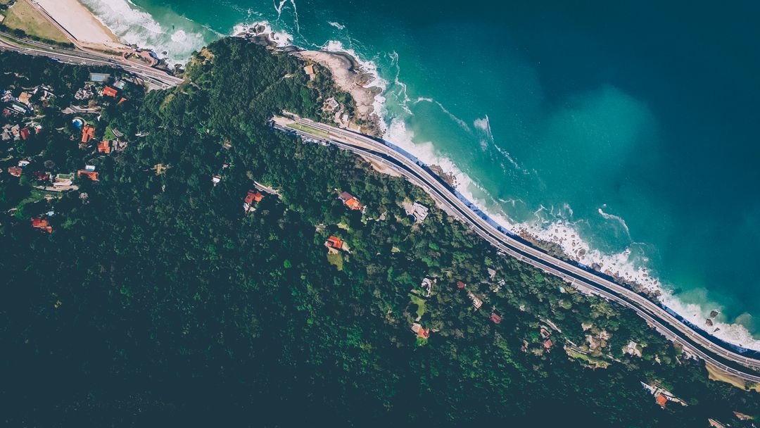 Aerial View of Coastal Road and Forested Cliff by Ocean - Free Images, Stock Photos and Pictures on Pikwizard.com