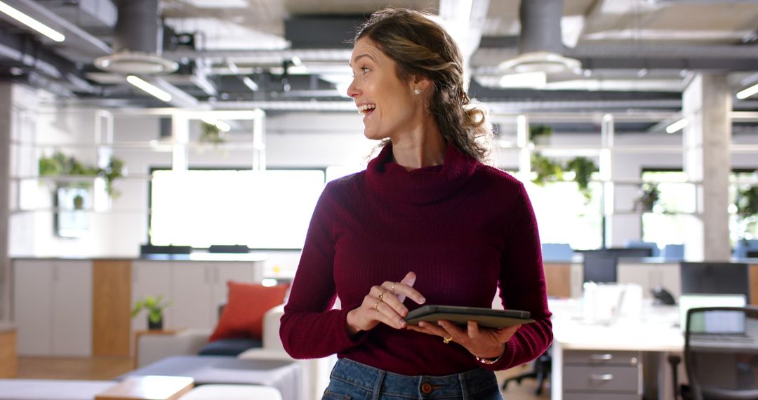 Smiling Businesswoman Holding Tablet in Modern Office Workspace - Free Images, Stock Photos and Pictures on Pikwizard.com