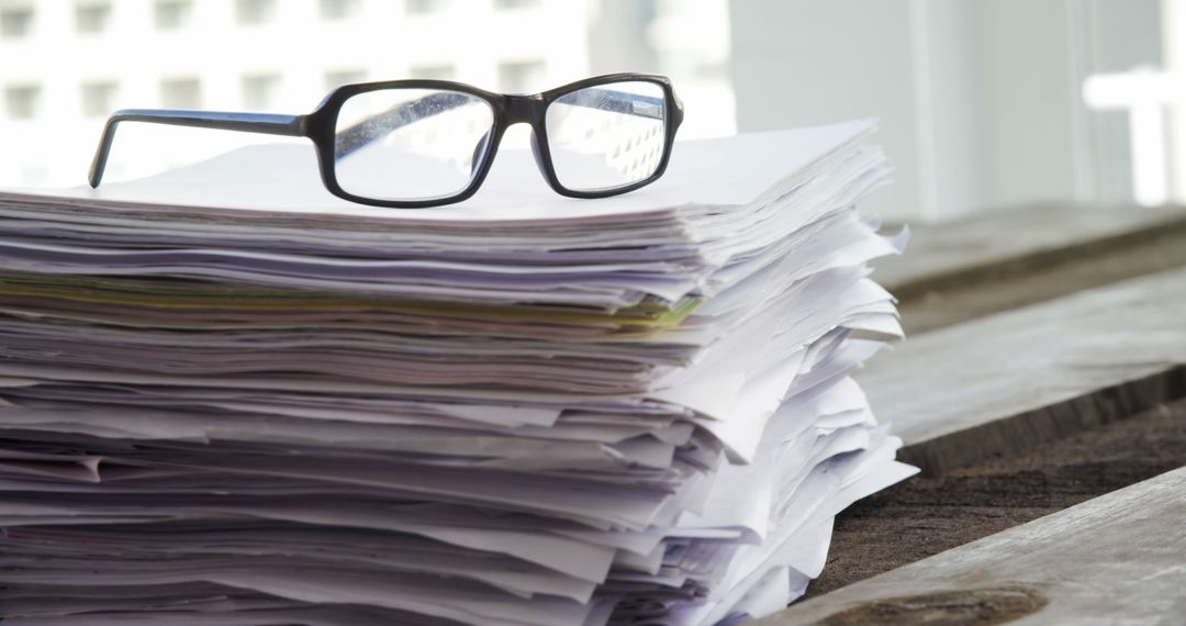 Glasses on Stacked Documents Suggesting Professional Work Pause