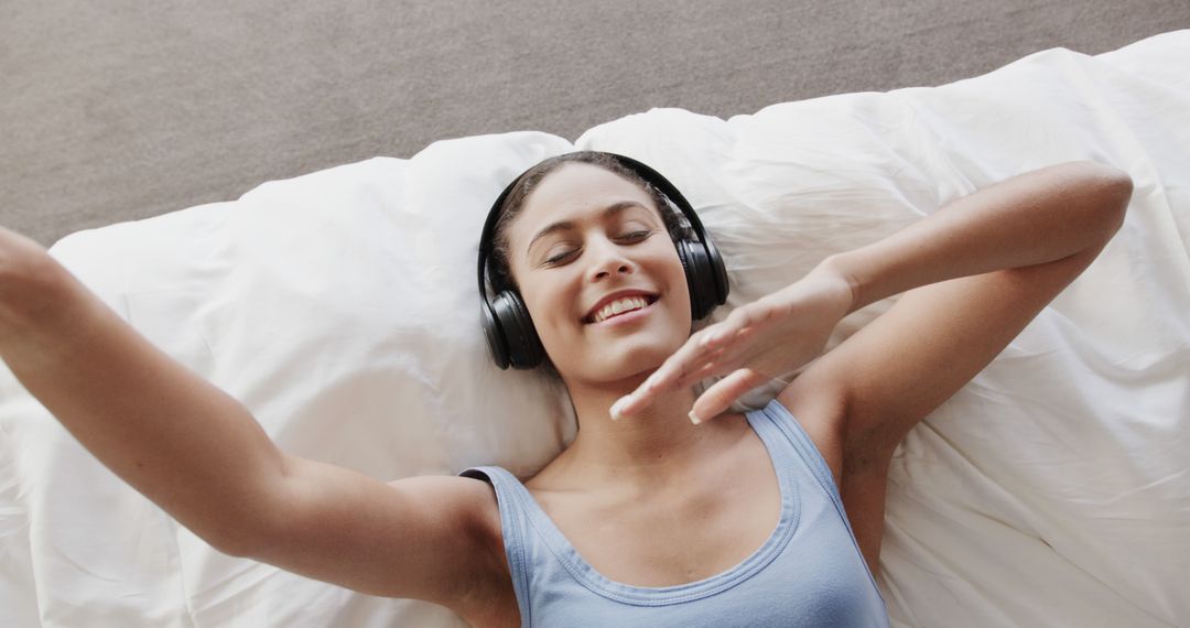 Young Woman Relaxing with Headphones, Enjoying Music on Bed - Free Images, Stock Photos and Pictures on Pikwizard.com