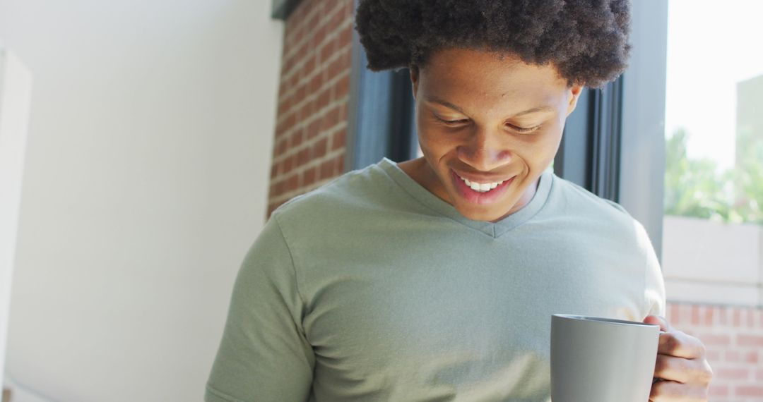 Man Enjoying Coffee and Smartphone Indoors, Natural Light