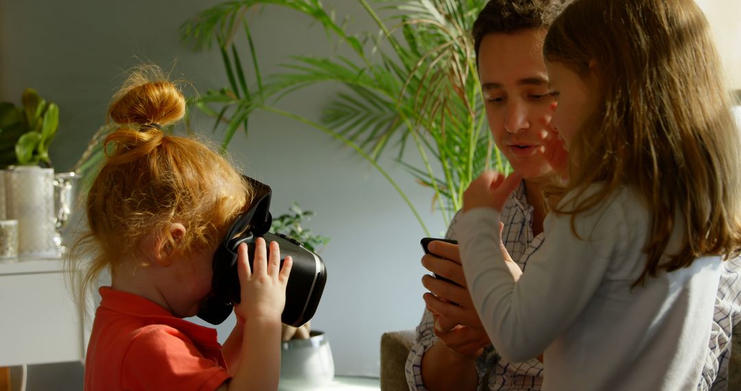 Father and Two Daughters Exploring Virtual Reality Indoors - Free Images, Stock Photos and Pictures on Pikwizard.com