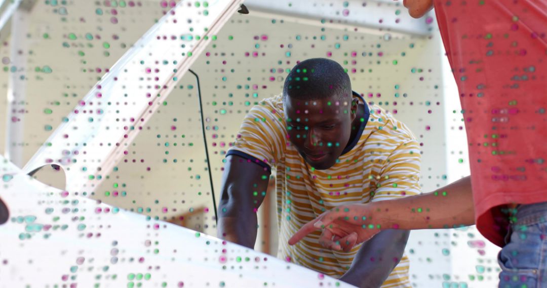 Inspecting car engine: man and friend leaning over open hood diagnosing vehicle in driveway