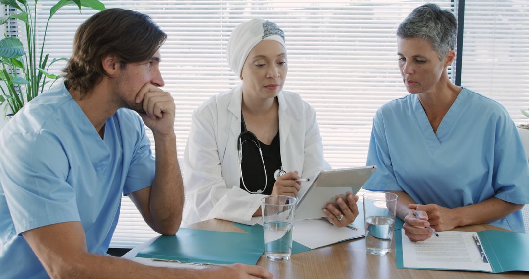 Medical Professionals Discussing Patient Case at Hospital Table - Free Images, Stock Photos and Pictures on Pikwizard.com