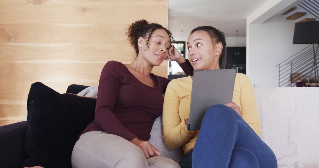 Two African American Women Relaxing on Couch and Holding Tablet - Free Images, Stock Photos and Pictures on Pikwizard.com