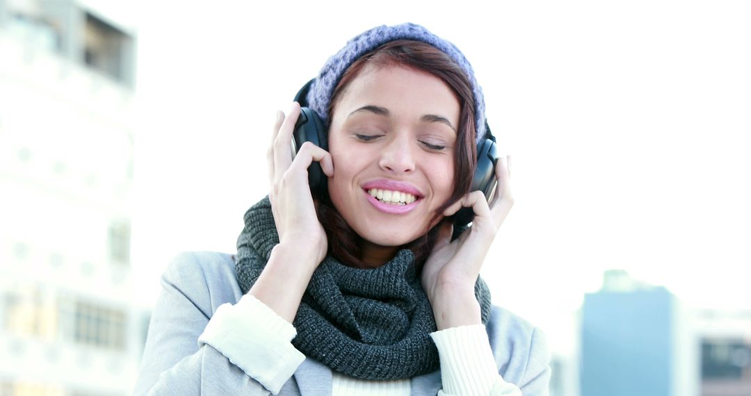 Smiling Woman Listening to Music Outdoors on a Winter Day - Free Images, Stock Photos and Pictures on Pikwizard.com