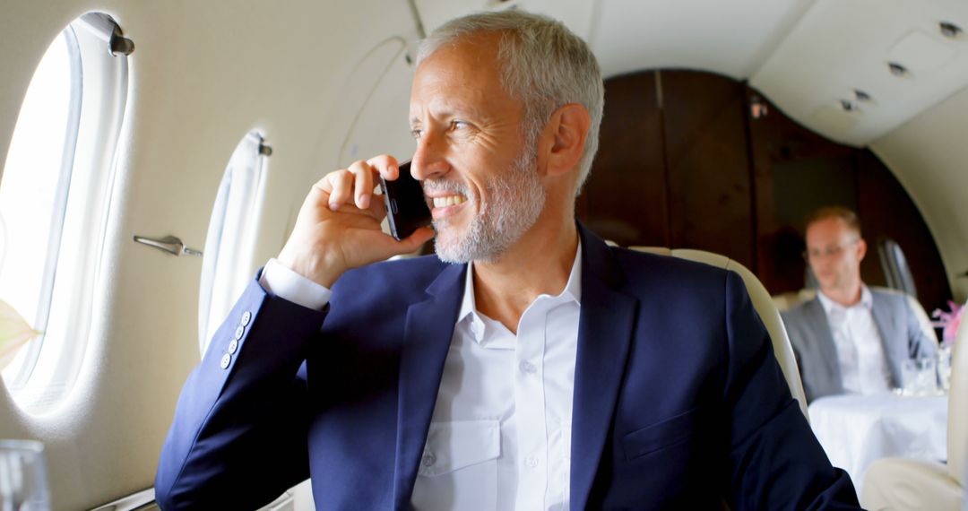 Businessman Smiling and Talking on Phone in Private Jet - Free Images, Stock Photos and Pictures on Pikwizard.com