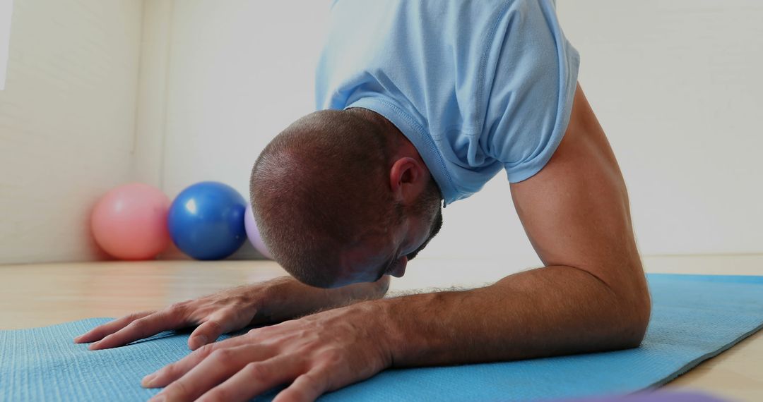 Man Practicing Yoga Child's Pose on Blue Mat - Free Images, Stock Photos and Pictures on Pikwizard.com