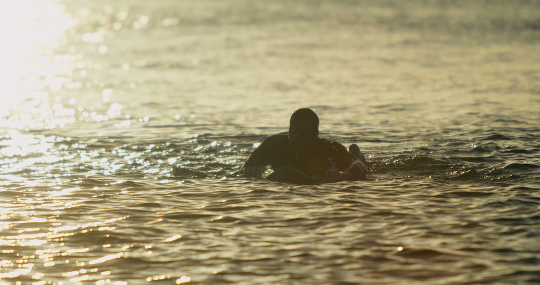 Person Surfing On Calm Ocean Waves During Golden Sunset - Free Images, Stock Photos and Pictures on Pikwizard.com