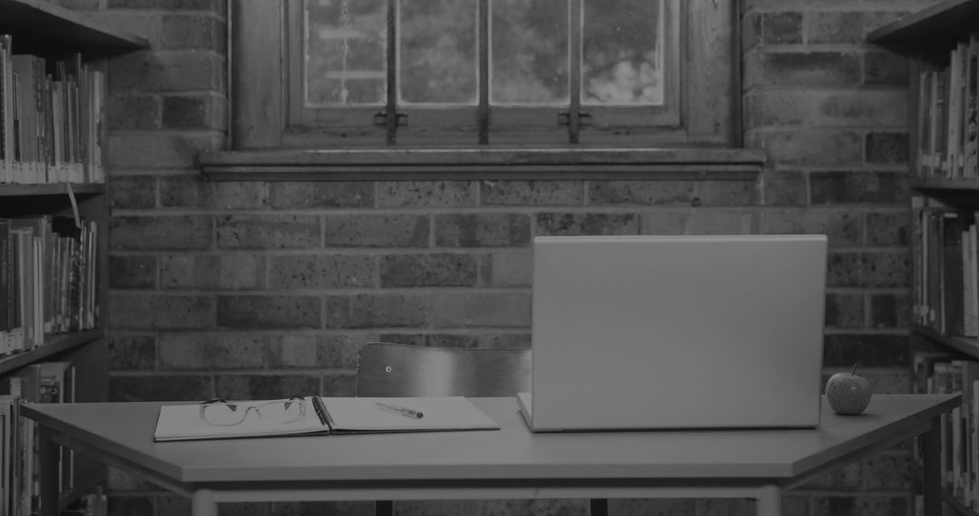 Laptop and Study Essentials on Desk in Quiet Library