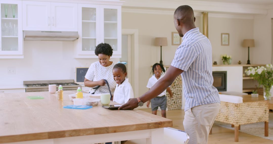 Father Helping Son While Family Enjoys Morning Routine in Kitchen