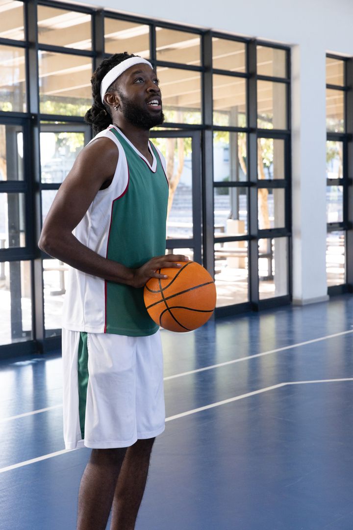 Basketball Player Preparing Throw Indoors with Sunlit Windows