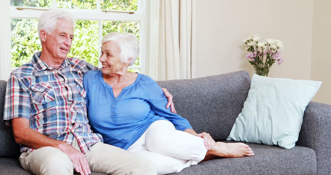 Happy Senior Couple Relaxing on Modern Living Room Sofa - Free Images, Stock Photos and Pictures on Pikwizard.com