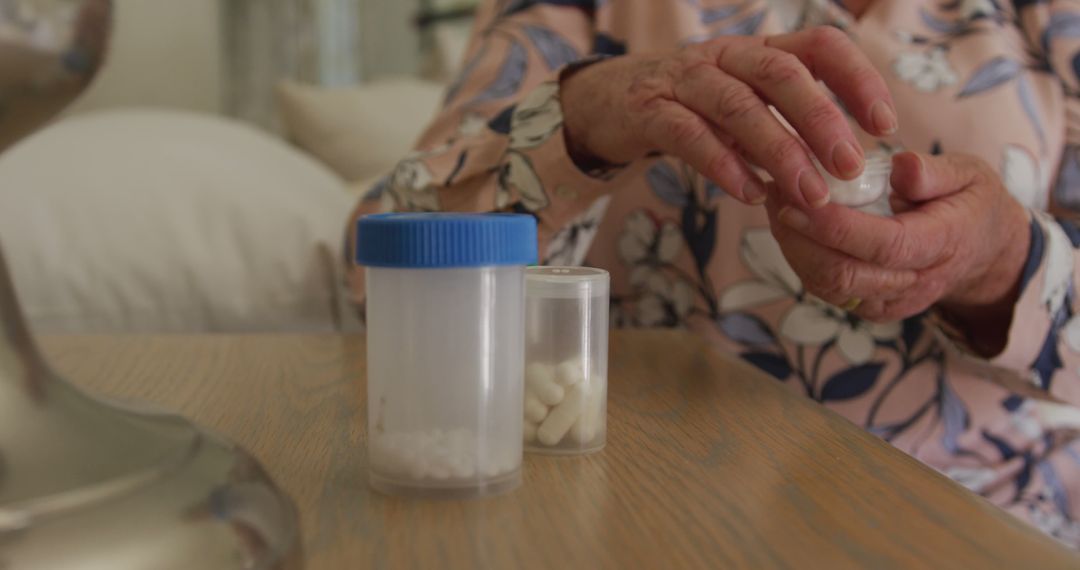 Elderly Hands Handling Medication Bottles on Wooden Table - Free Images, Stock Photos and Pictures on Pikwizard.com