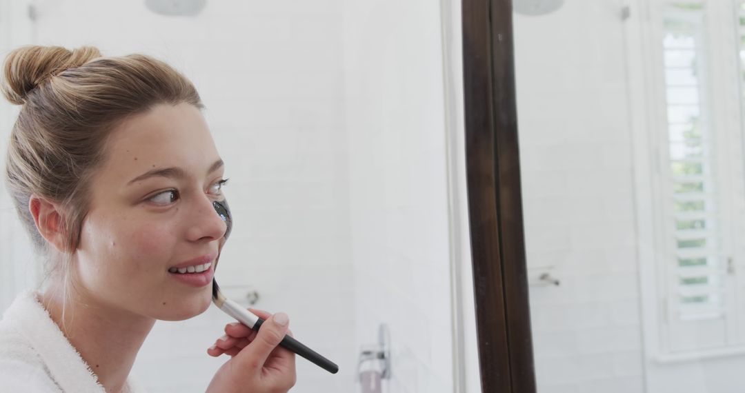 Young Woman Applying Makeup in Front of Bathroom Mirror - Free Images, Stock Photos and Pictures on Pikwizard.com