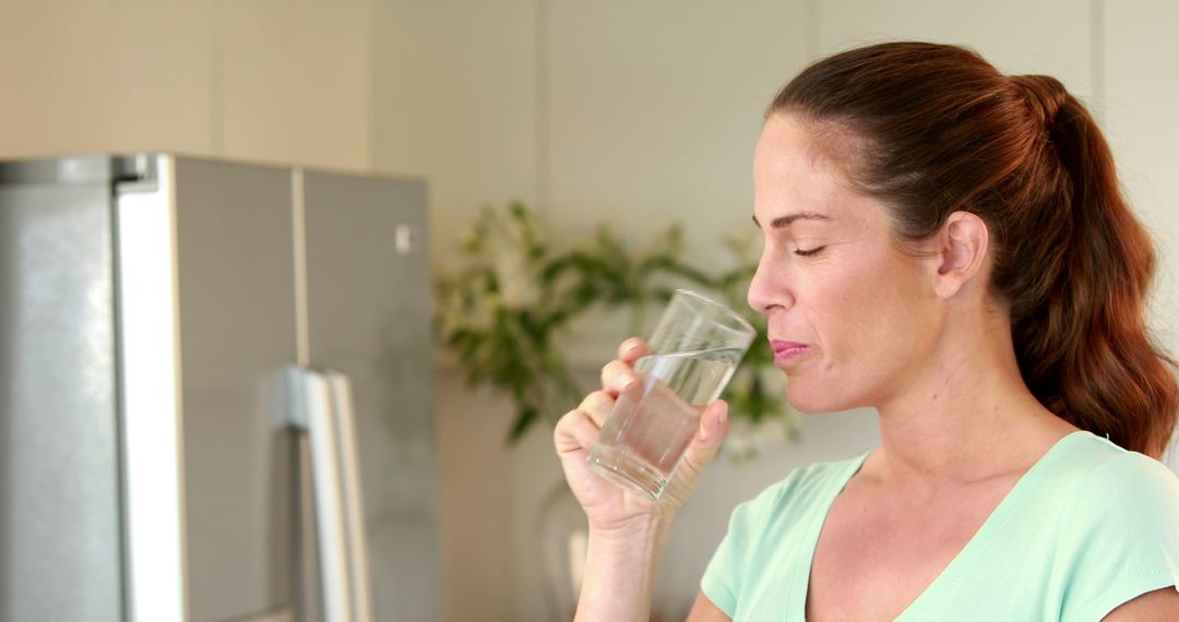 Woman Drinking Water in Modern Kitchen Area - Free Images, Stock Photos and Pictures on Pikwizard.com