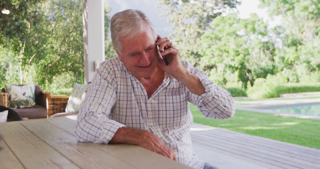 Senior Man Laughing on Phone Call in Outdoor Patio - Free Images, Stock Photos and Pictures on Pikwizard.com