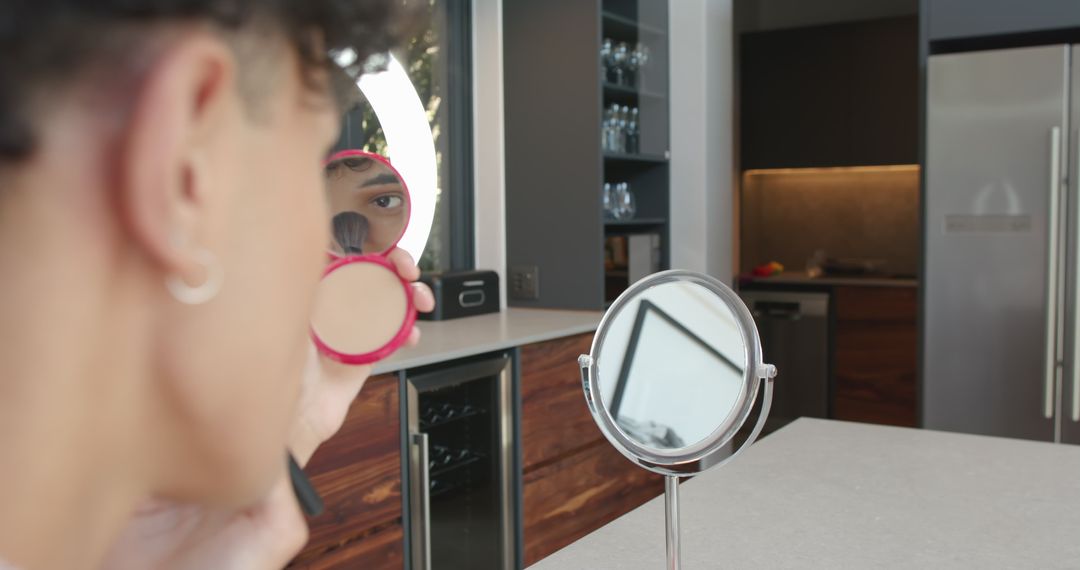 Man Applying Compact Powder in Modern Kitchen Setting